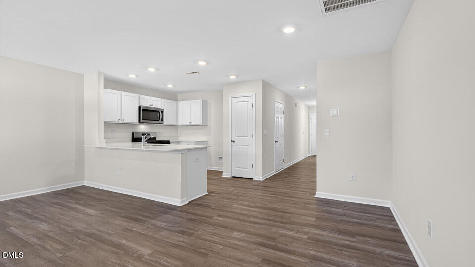 104 Clementine Street Angier, NC 27501 - Photo 8 of 27 a view of kitchen with refrigerator stove and wooden floor