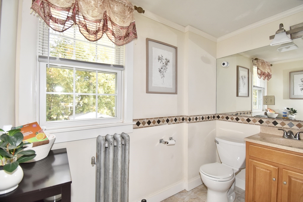 77 Dorset Street Springfield, MA 01108 - Photo 17 of 34 a bathroom with a sink mirror toilet and window