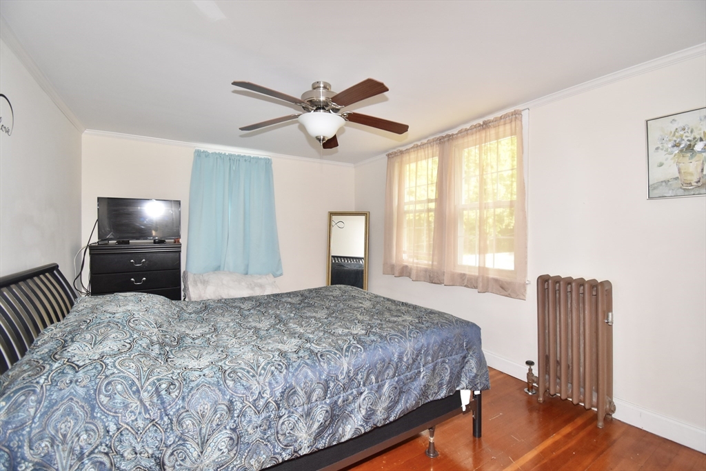 77 Dorset Street Springfield, MA 01108 - Photo 20 of 34 a bedroom with a bed and a chandelier