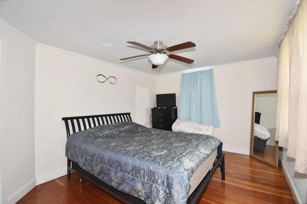 77 Dorset Street Springfield, MA 01108 - Photo 21 of 34 a bedroom with a bed and a chandelier