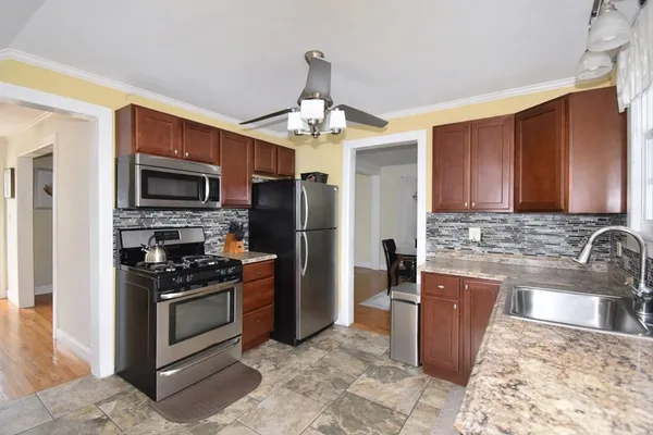 a kitchen with stainless steel appliances granite countertop a stove refrigerator sink and microwave