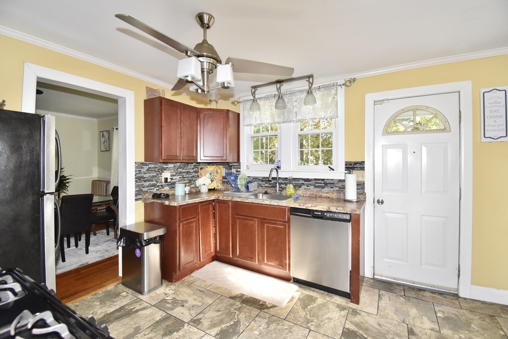 77 Dorset Street Springfield, MA 01108 - Photo 7 of 34 a kitchen with stainless steel appliances granite countertop a refrigerator a sink dishwasher a stove a dining table and chairs with wooden floor