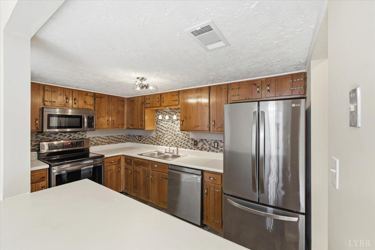 154 Kitty Hawk Square Lynchburg, VA 24502 - Photo 10 of 30 a kitchen with stainless steel appliances granite countertop a refrigerator and a stove top oven