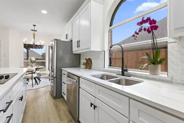 a kitchen with stainless steel appliances granite countertop a sink refrigerator and cabinets