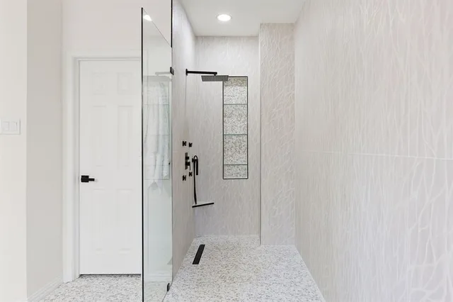 a bathroom with a shower and a glass door