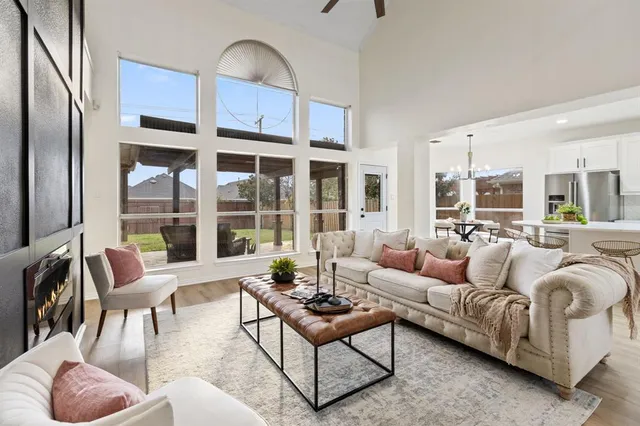 a living room with furniture wooden floor and a large window