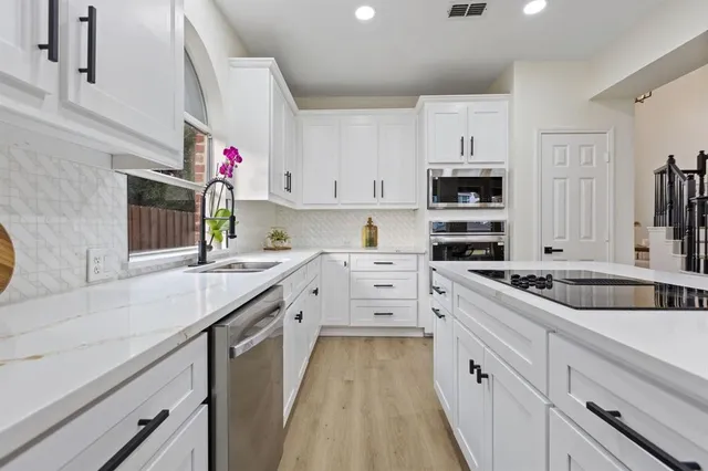 a kitchen that has a lot of cabinets and wooden floor