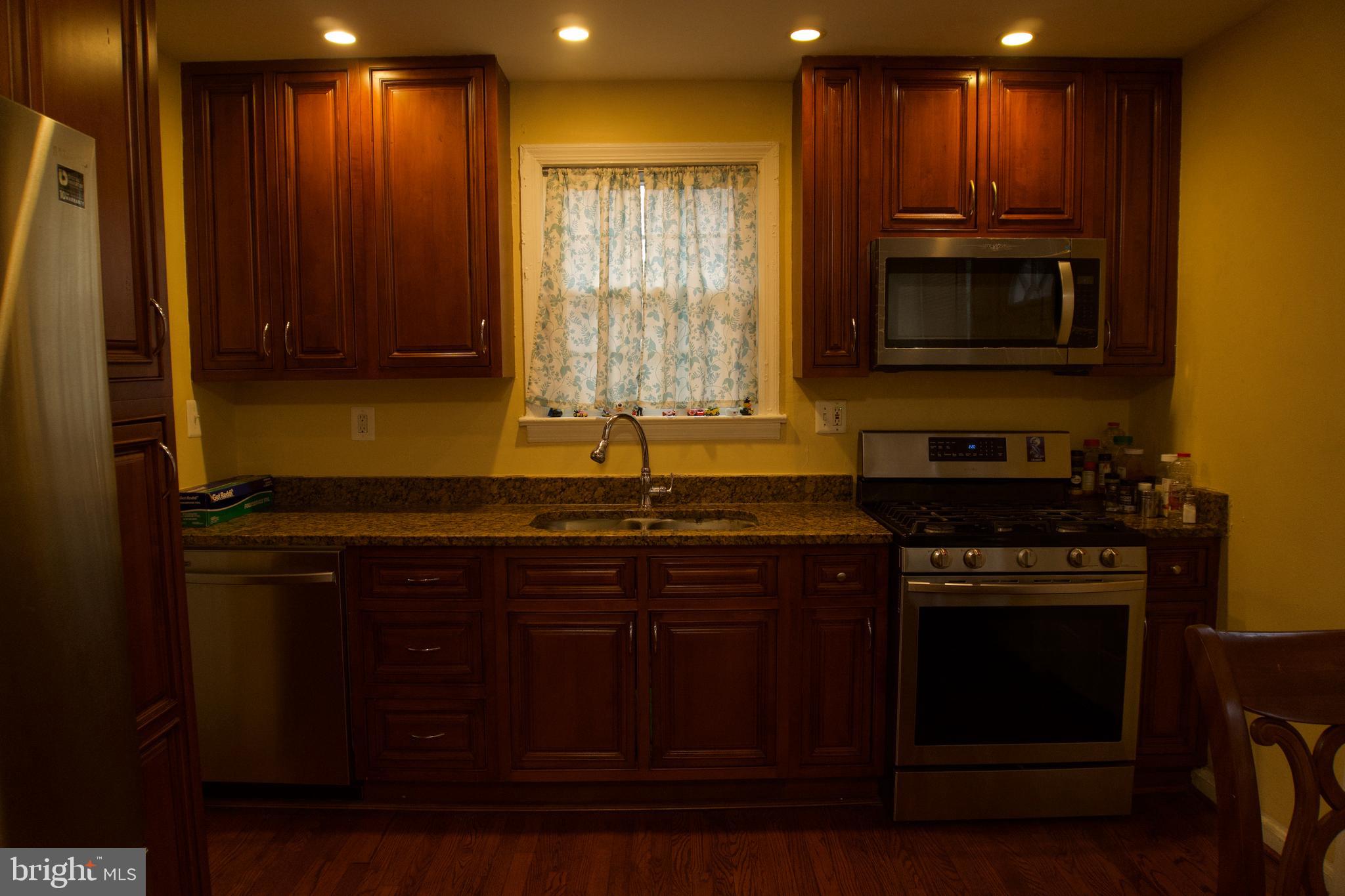 5702 Landover Road Hyattsville, MD 20784 - Photo 5 of 18 a kitchen with wooden cabinets and a stove top oven
