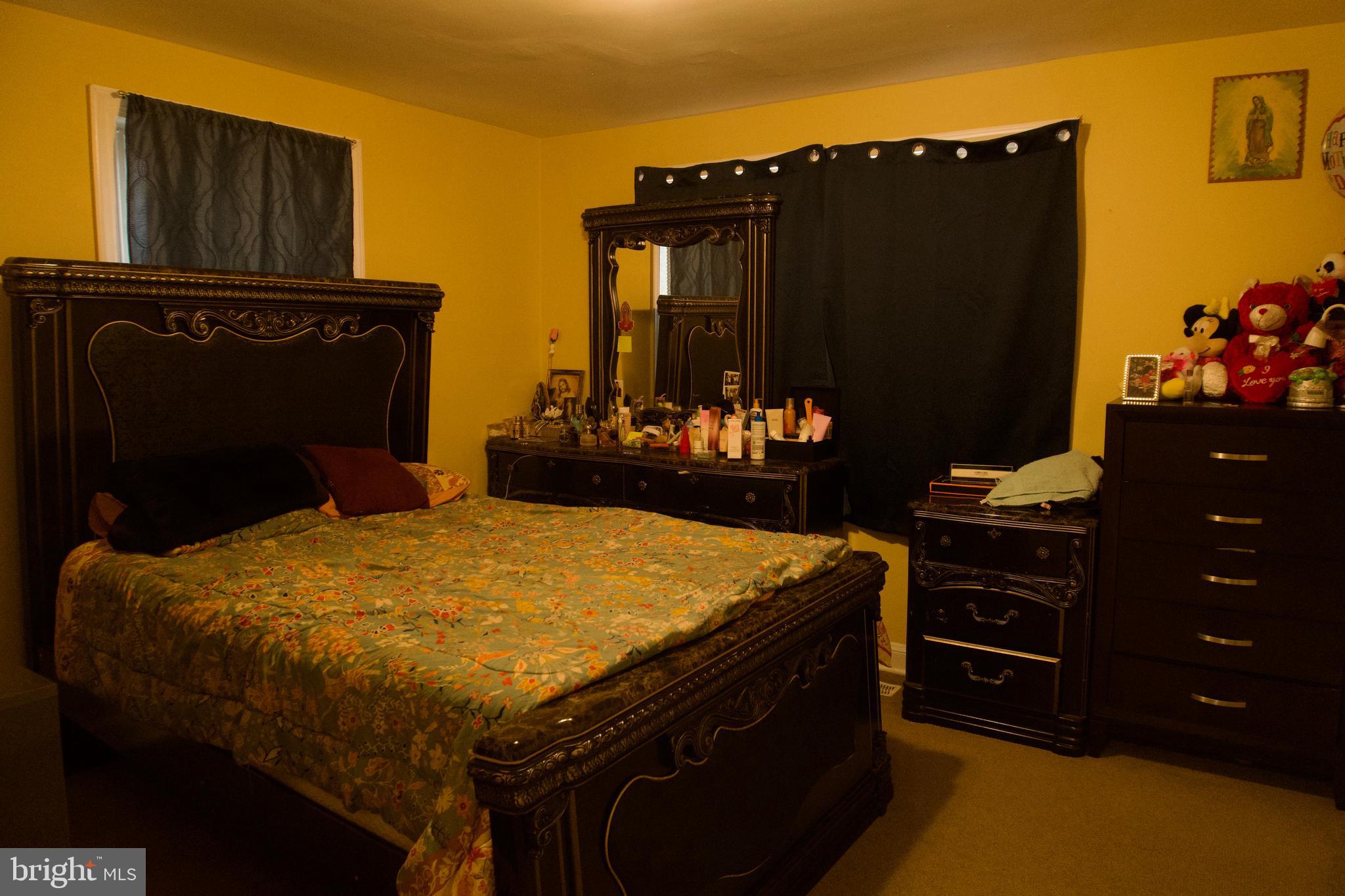 5702 Landover Road Hyattsville, MD 20784 - Photo 7 of 18 a bed sitting in a bedroom next to a cabinet