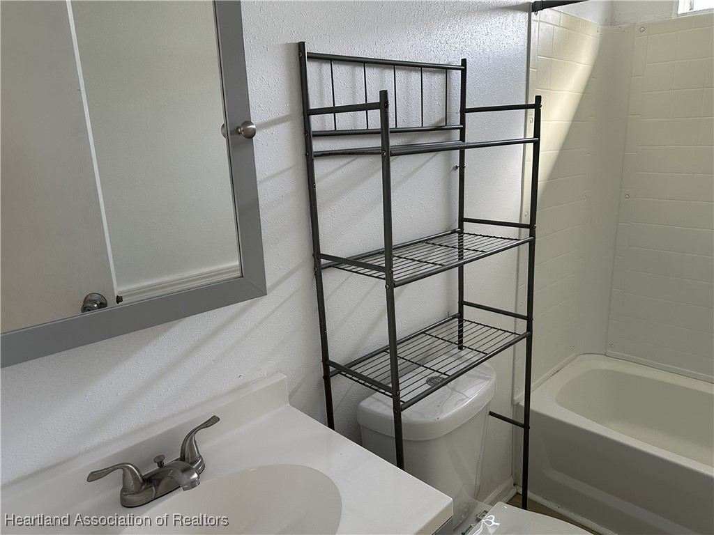 2273 Kansas Street Sebring, FL 33870 - Photo 5 of 10 a bathroom with a sink and mirror with bathtub
