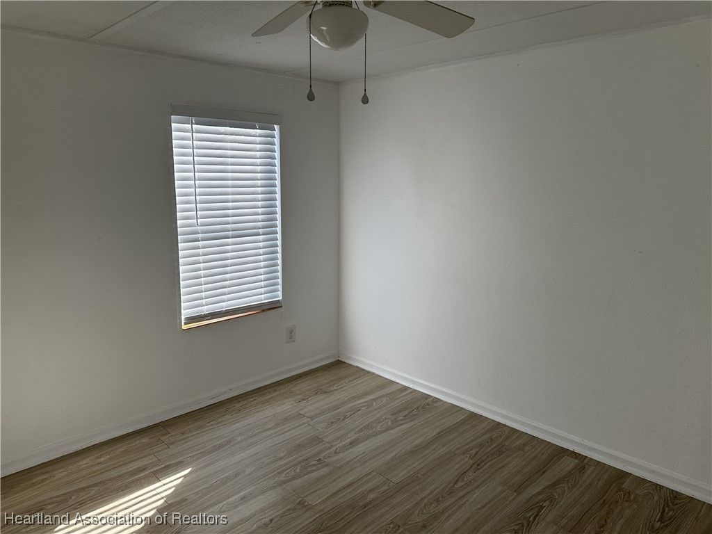 2273 Kansas Street Sebring, FL 33870 - Photo 6 of 10 a view of an empty room with wooden floor and a window