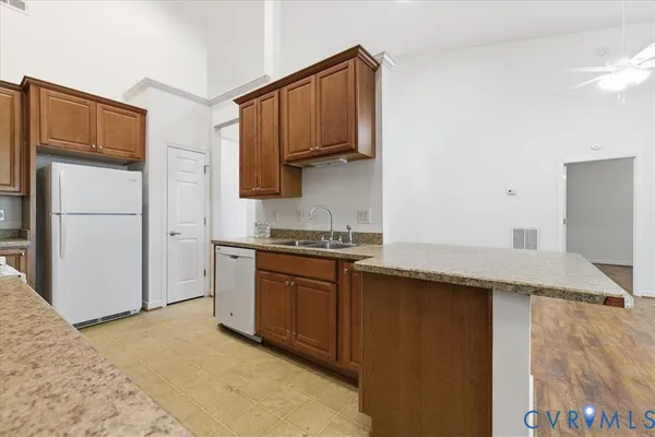 a kitchen with stainless steel appliances granite countertop a refrigerator a stove and a sink with wooden floor