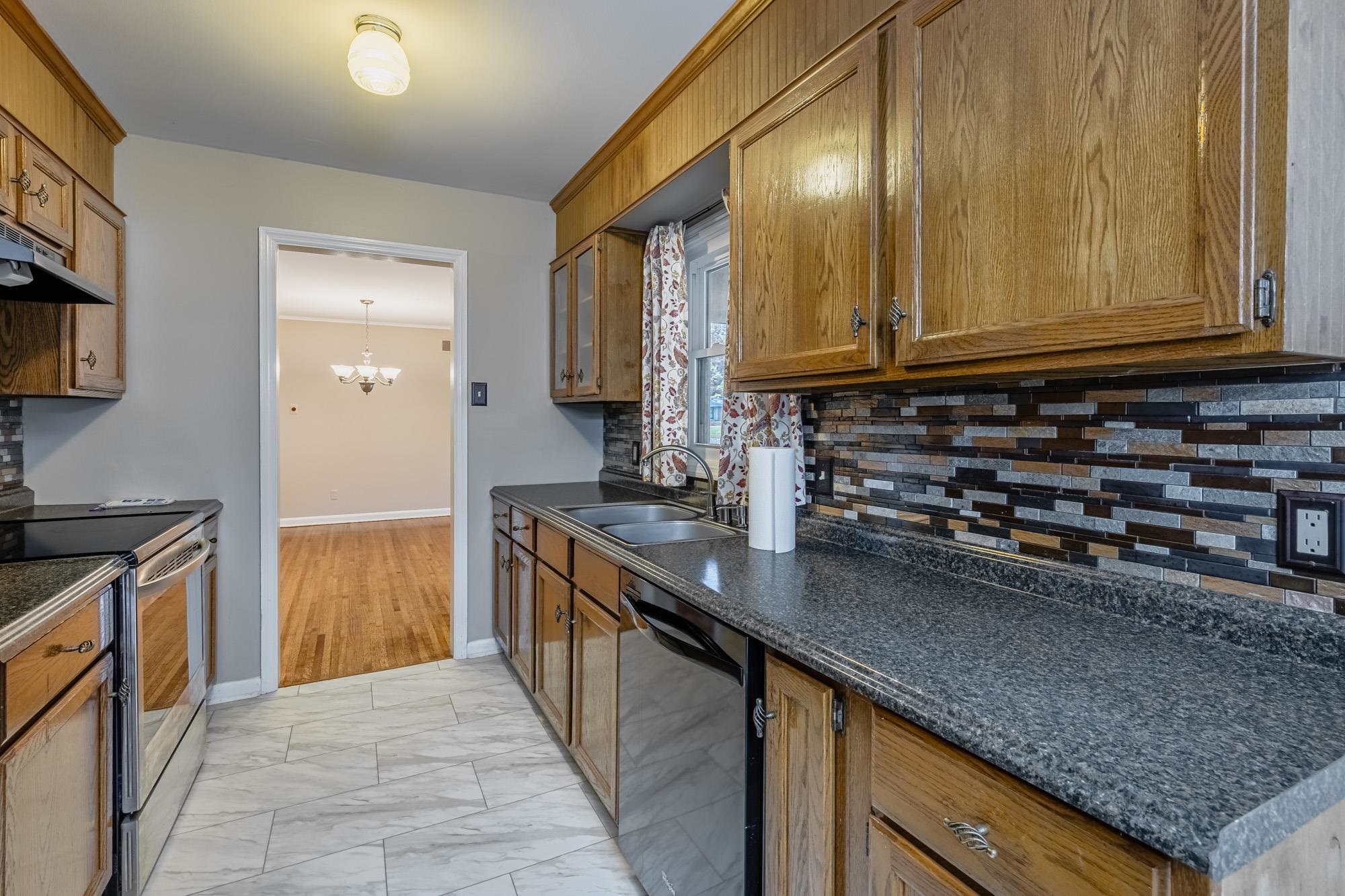 1081 Ivy Road Memphis, TN 38117 - Photo 17 of 25 a kitchen with stainless steel appliances granite countertop a sink a stove and a wooden cabinets