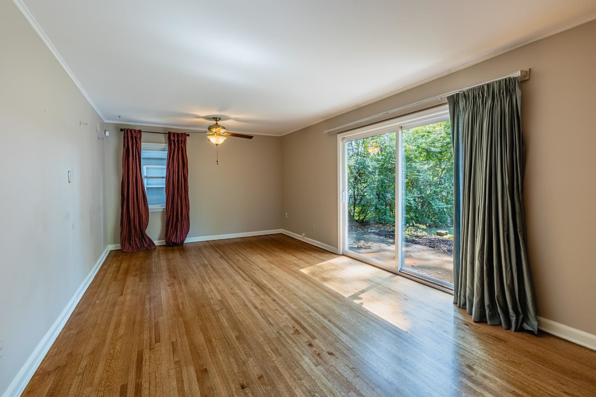 1081 Ivy Road Memphis, TN 38117 - Photo 19 of 25 a view of an empty room with wooden floor and a window