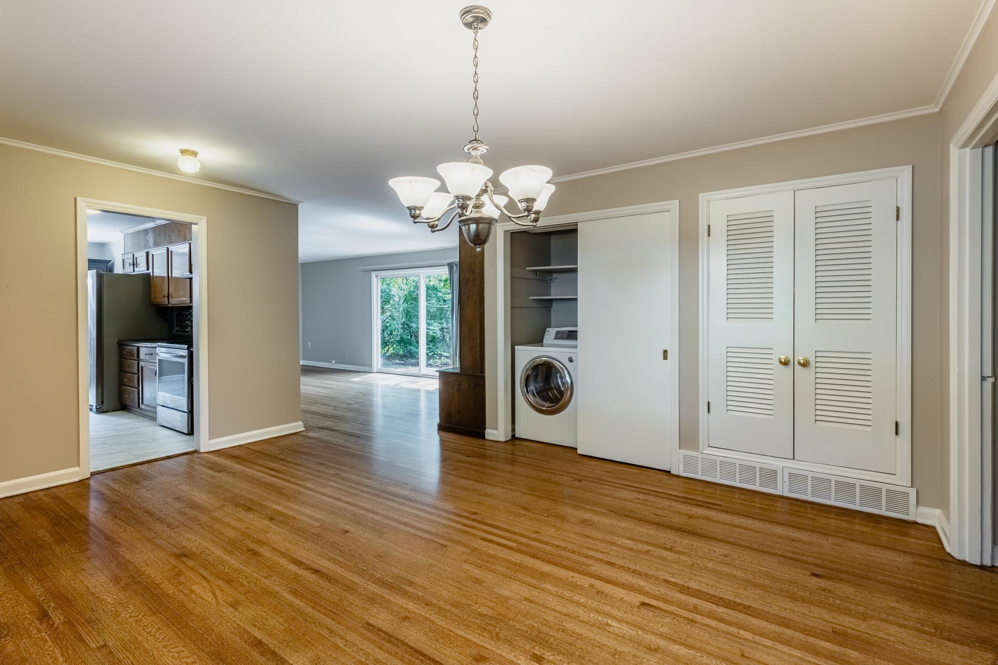1081 Ivy Road Memphis, TN 38117 - Photo 5 of 25 a view of an empty room with wooden floor and a kitchen