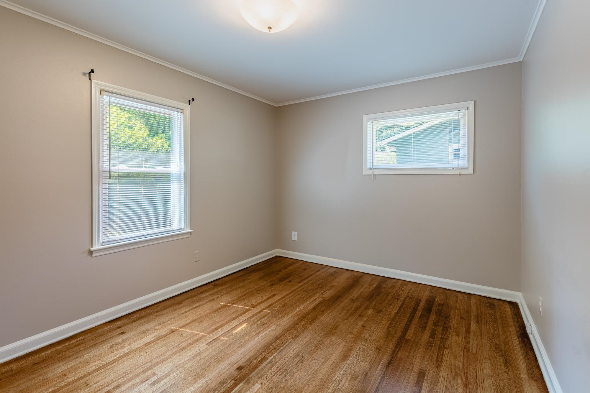 1081 Ivy Road Memphis, TN 38117 - Photo 9 of 25 a view of an empty room with wooden floor and a window
