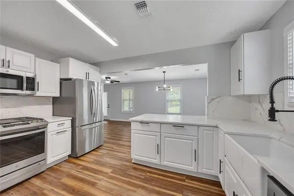 a kitchen with white cabinets and stainless steel appliances