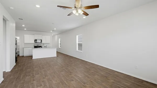 a view of kitchen with refrigerator and white cabinets