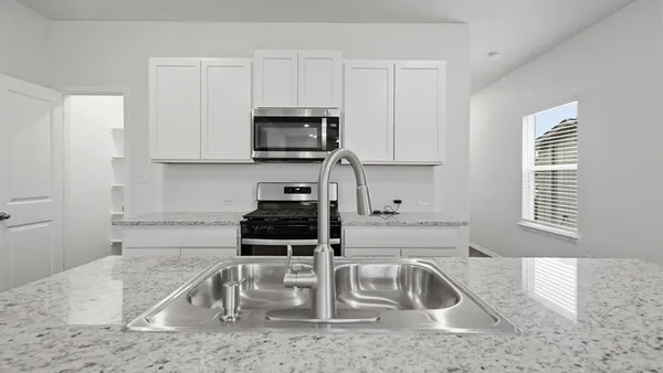 a kitchen with a sink and a stove top oven