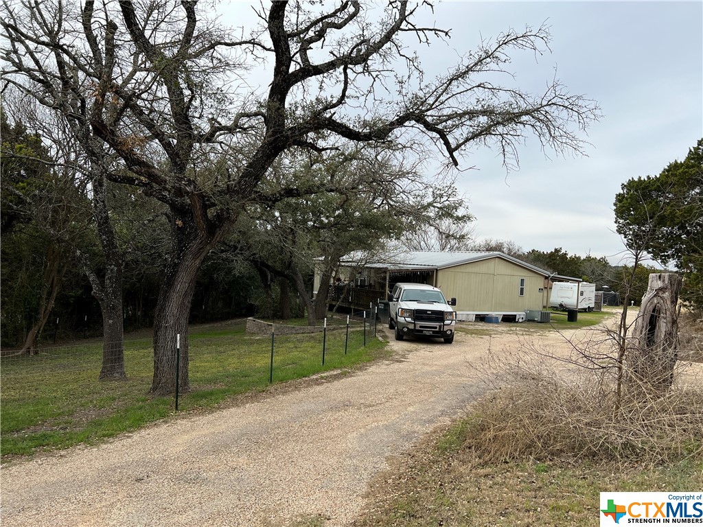a view of a house with large trees and a big yard