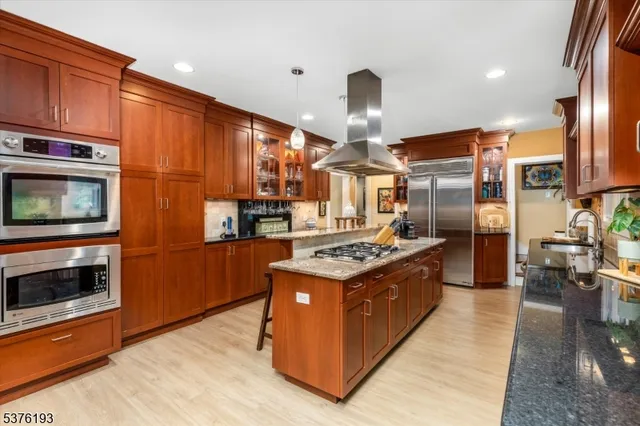 a kitchen with stainless steel appliances granite countertop wooden cabinets a sink and a stove