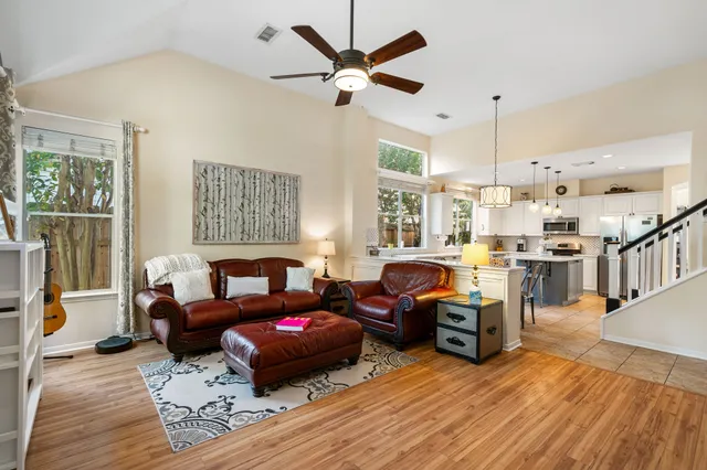 a living room with furniture kitchen view and a large window