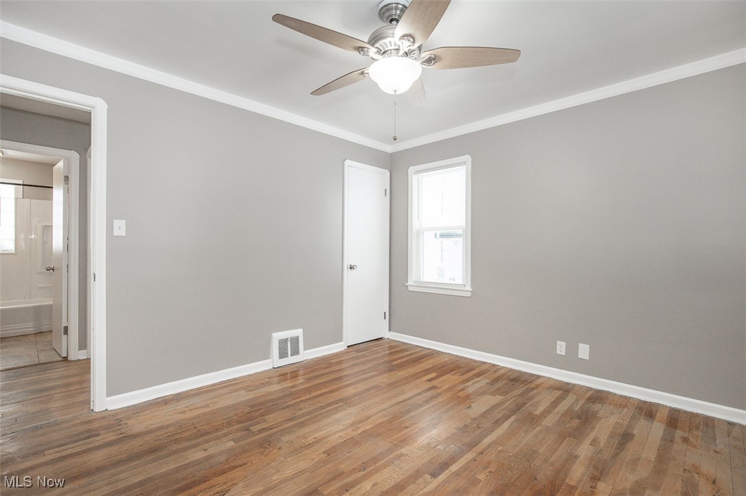12328 Granger Road Cleveland, OH 44125 - Photo 11 of 37 Spare room featuring wood finished floors, ornamental molding, and ceiling fan