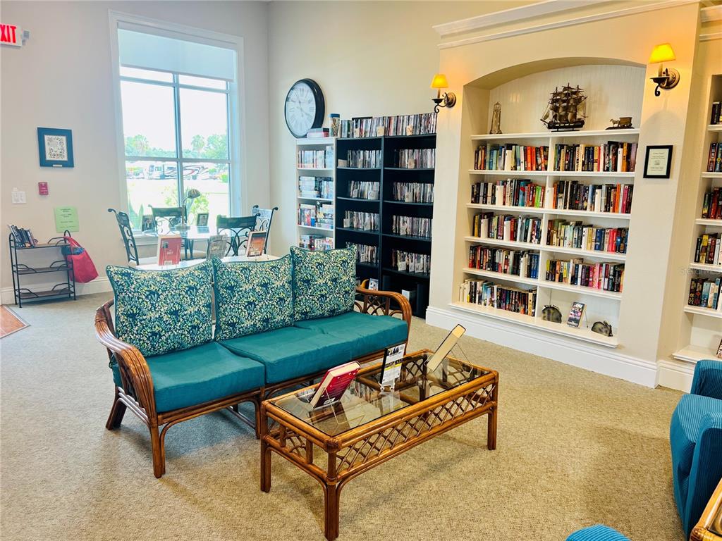 9477 Southeast 49th Terrace Webster, FL 33597 - Photo 21 of 31 a living room with furniture and a book shelf