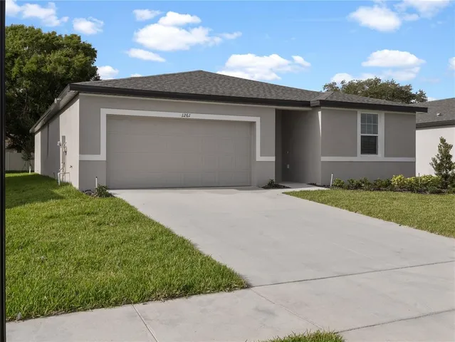 a front view of a house with a garden and yard