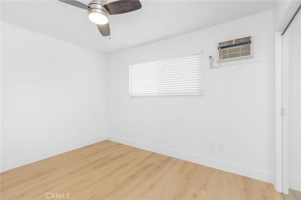 an empty room with a window and a ceiling fan