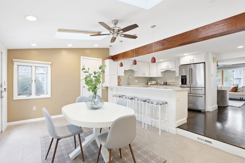 28 Longfellow Road Natick, MA 01760 - Photo 7 of 30 a kitchen with stainless steel appliances kitchen island granite countertop a dining table chairs and white cabinets