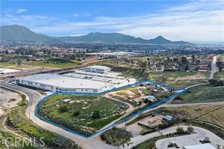 an aerial view of a residential houses with outdoor space and trees