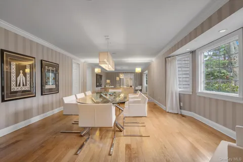 a living room with furniture a large window and wooden floor
