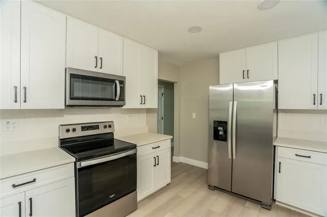 a kitchen with stainless steel appliances a refrigerator stove and microwave