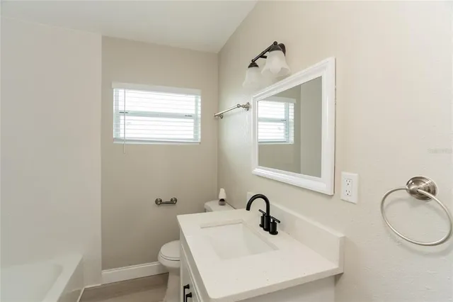 a bathroom with a sink mirror and toilet