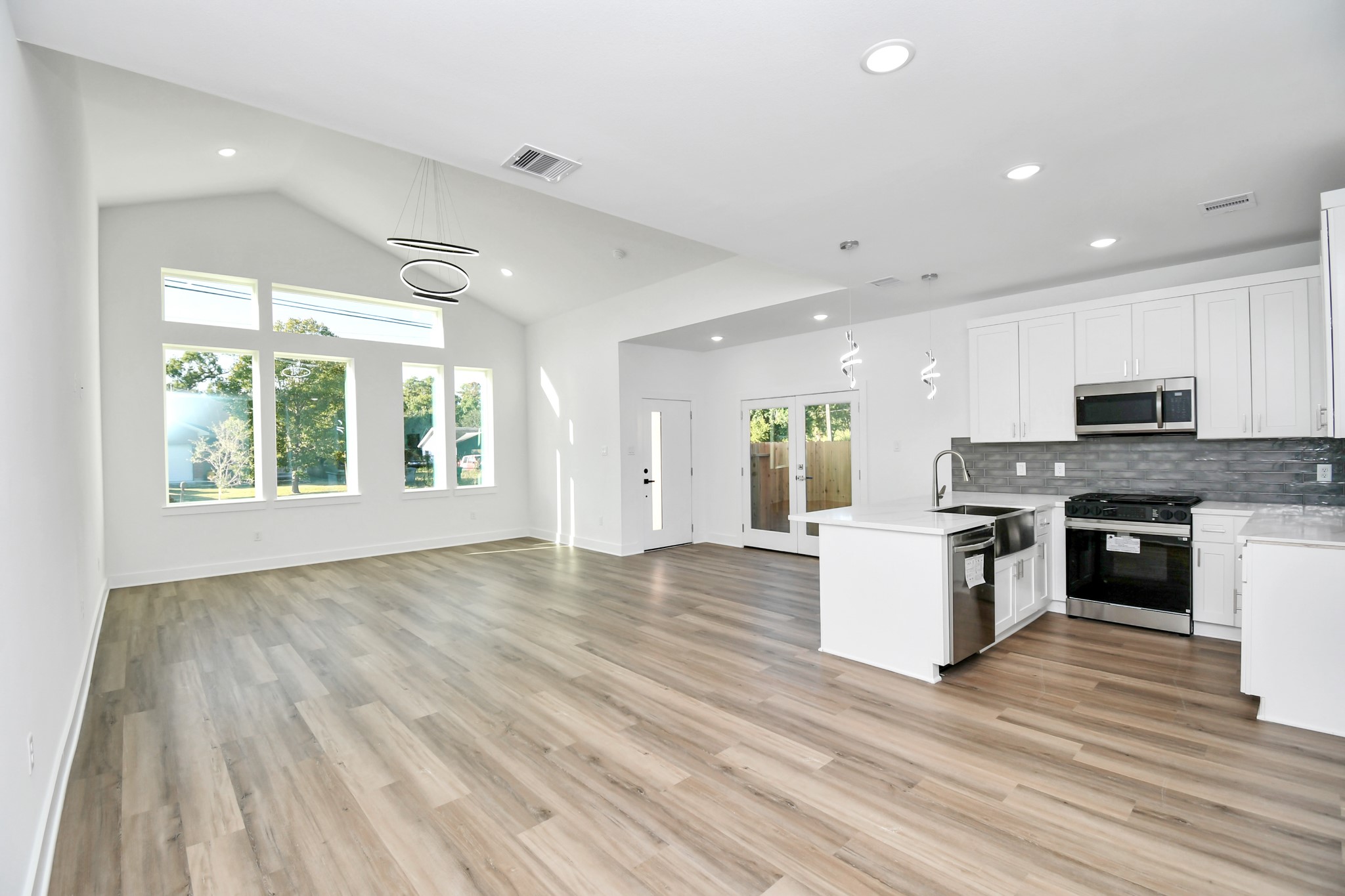 8109 Hamlet Street Houston, TX 77078 - Photo 13 of 50 a large kitchen with granite countertop a stove top oven a sink and white cabinets with wooden floor