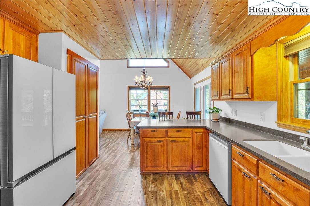 98 New Ridge Lane Piney Creek, NC 28663 - Photo 13 of 50 a kitchen with stainless steel appliances granite countertop a refrigerator a sink dishwasher a stove and white countertops with wooden floor