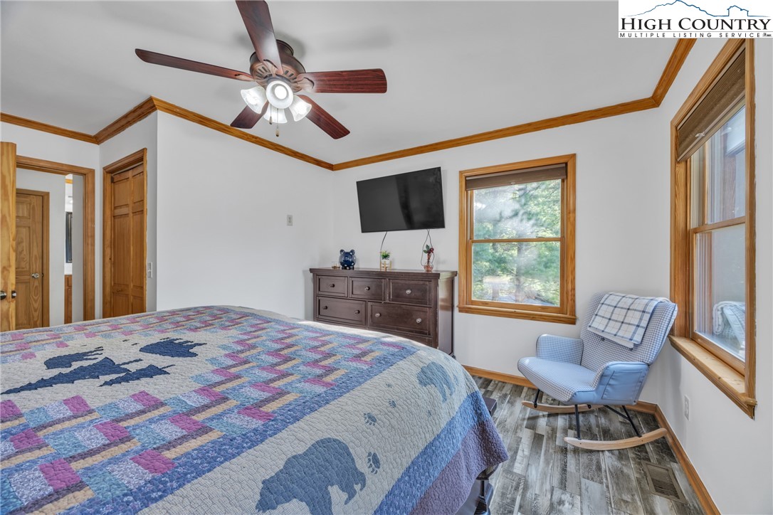 98 New Ridge Lane Piney Creek, NC 28663 - Photo 17 of 50 a spacious bedroom with a bed and a chandelier