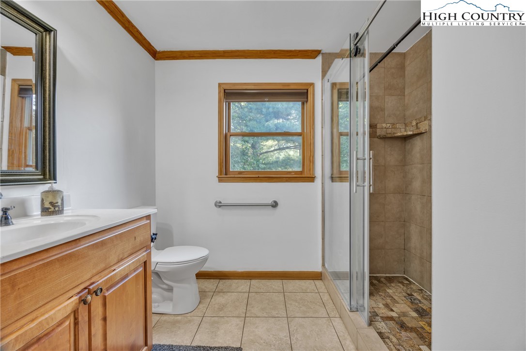 98 New Ridge Lane Piney Creek, NC 28663 - Photo 19 of 50 a bathroom with a granite countertop sink a toilet and shower