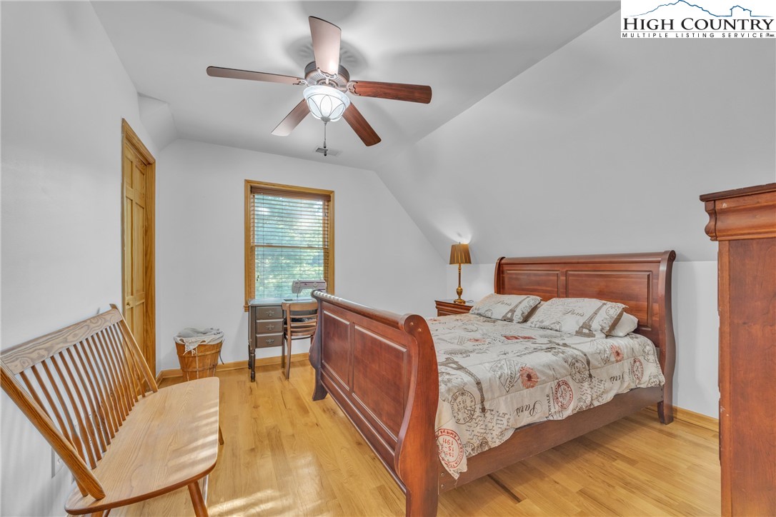 98 New Ridge Lane Piney Creek, NC 28663 - Photo 23 of 50 a bedroom with a bed and a chandelier