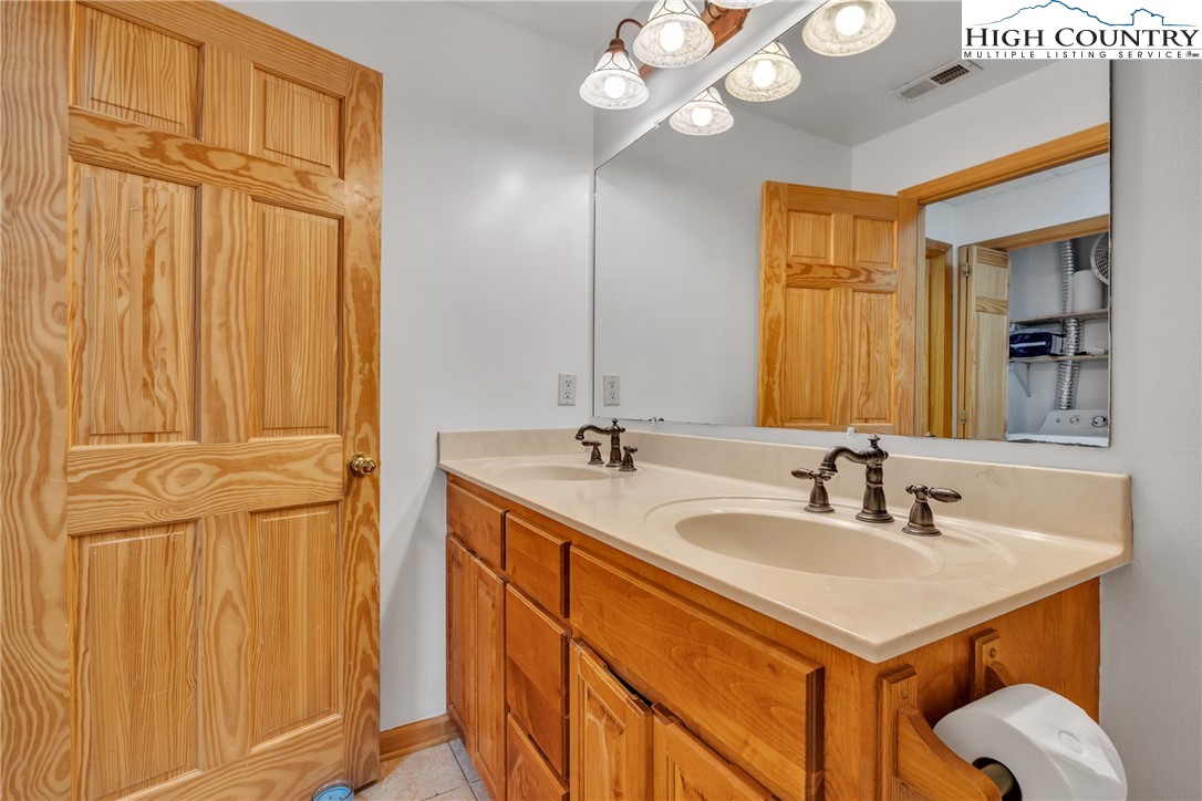 98 New Ridge Lane Piney Creek, NC 28663 - Photo 34 of 50 a bathroom with a sink a mirror and a shower
