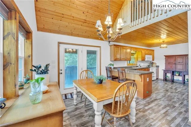 a large kitchen with stainless steel appliances granite countertop a refrigerator a stove and a dining table next to a window