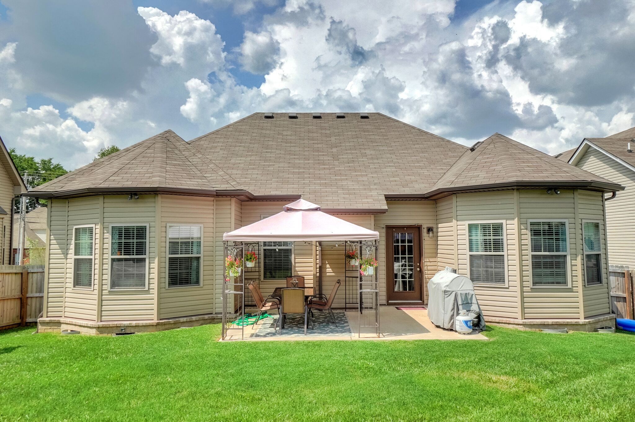 1057 Golf View Way Spring Hill, TN 37174 - Photo 29 of 29 a patio with a table and chairs under an umbrella