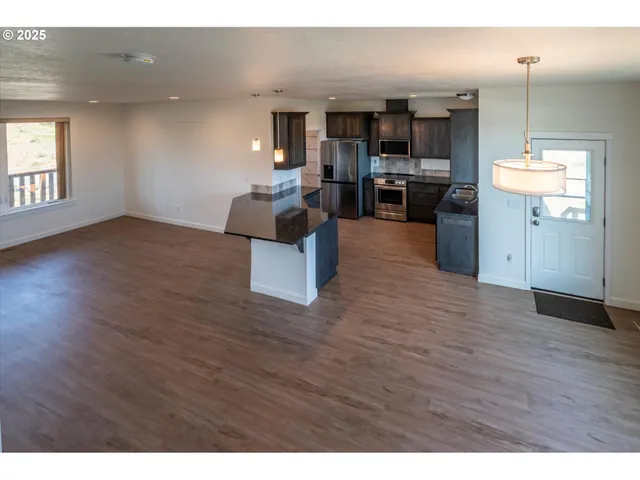 a kitchen with stainless steel appliances kitchen island granite countertop a refrigerator a stove top oven and a sink