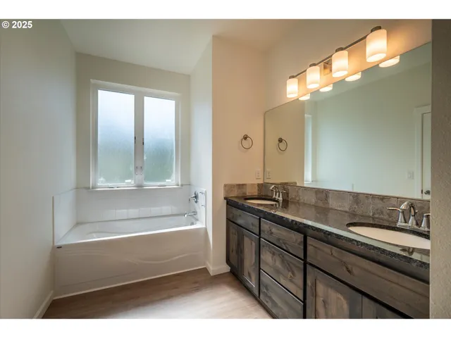 a bathroom with a tub sink and mirror