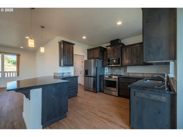 a kitchen with wooden floors and wooden cabinets