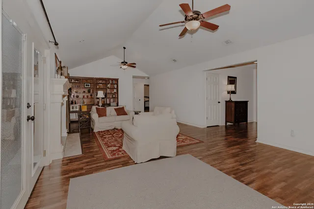 a living room with couches and a dining table with wooden floor