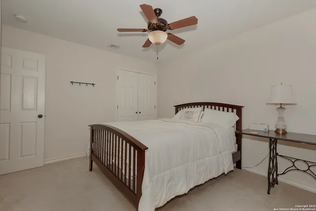 a bedroom with a bed and a ceiling fan