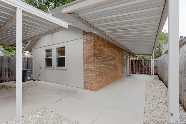 a view of a white house and a car parked in front of it