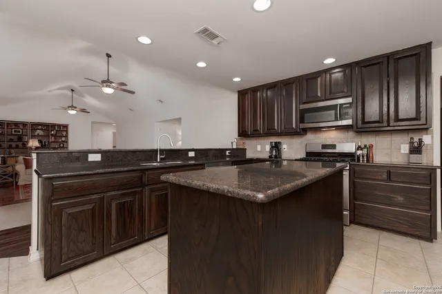 a kitchen with a sink and a stove top oven with wooden floor